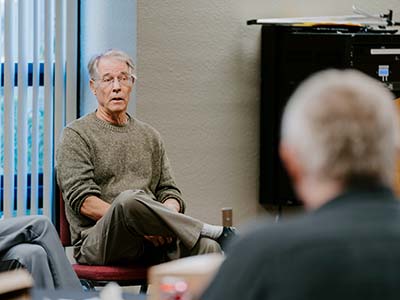 Kim Stanley Robinson sitting crosslegged speaking to students