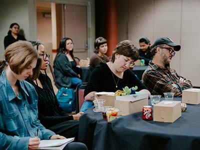 Students taking notes while listening to speaker