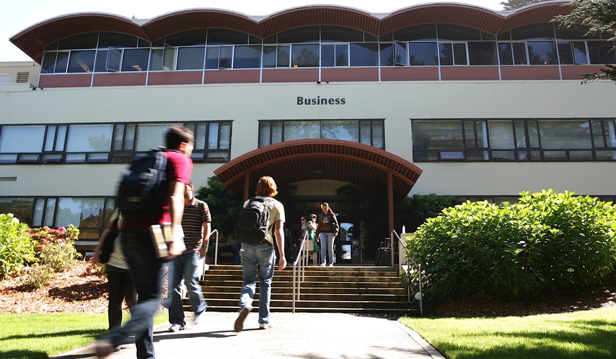 Students walk into the Lam Family College of Business building