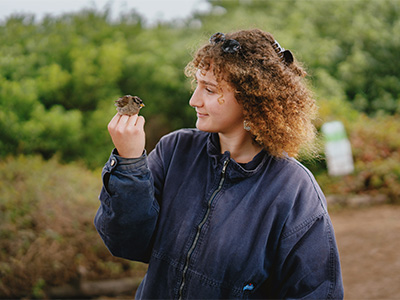 Lilly holding and looking at a small bird
