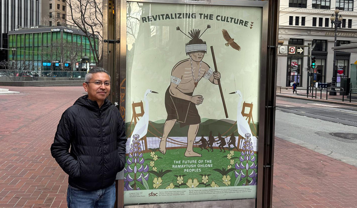 Marcelo Potosi stands on Market Street next to his Revitalizing the Culture poster for the series titled The Future of the Ramaytush Ohlone