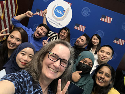 Caryn takes a selfie with several other fellows 