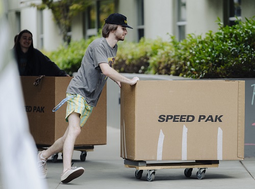 Students push big boxes into a dorm