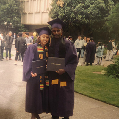 While dressed in SFSU regalia, James and Paris pose for a photo on the SFSU campus. 