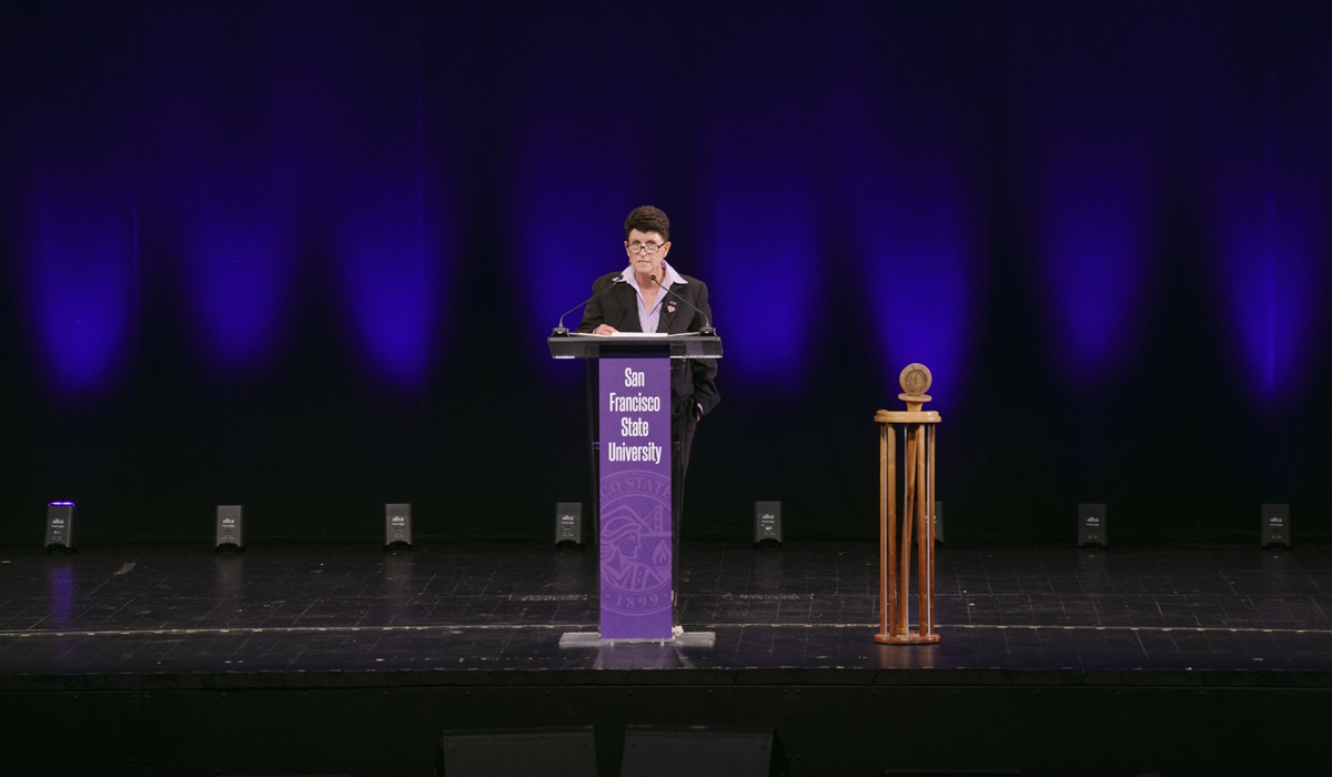 Lynn Mahoney speaking at a podium