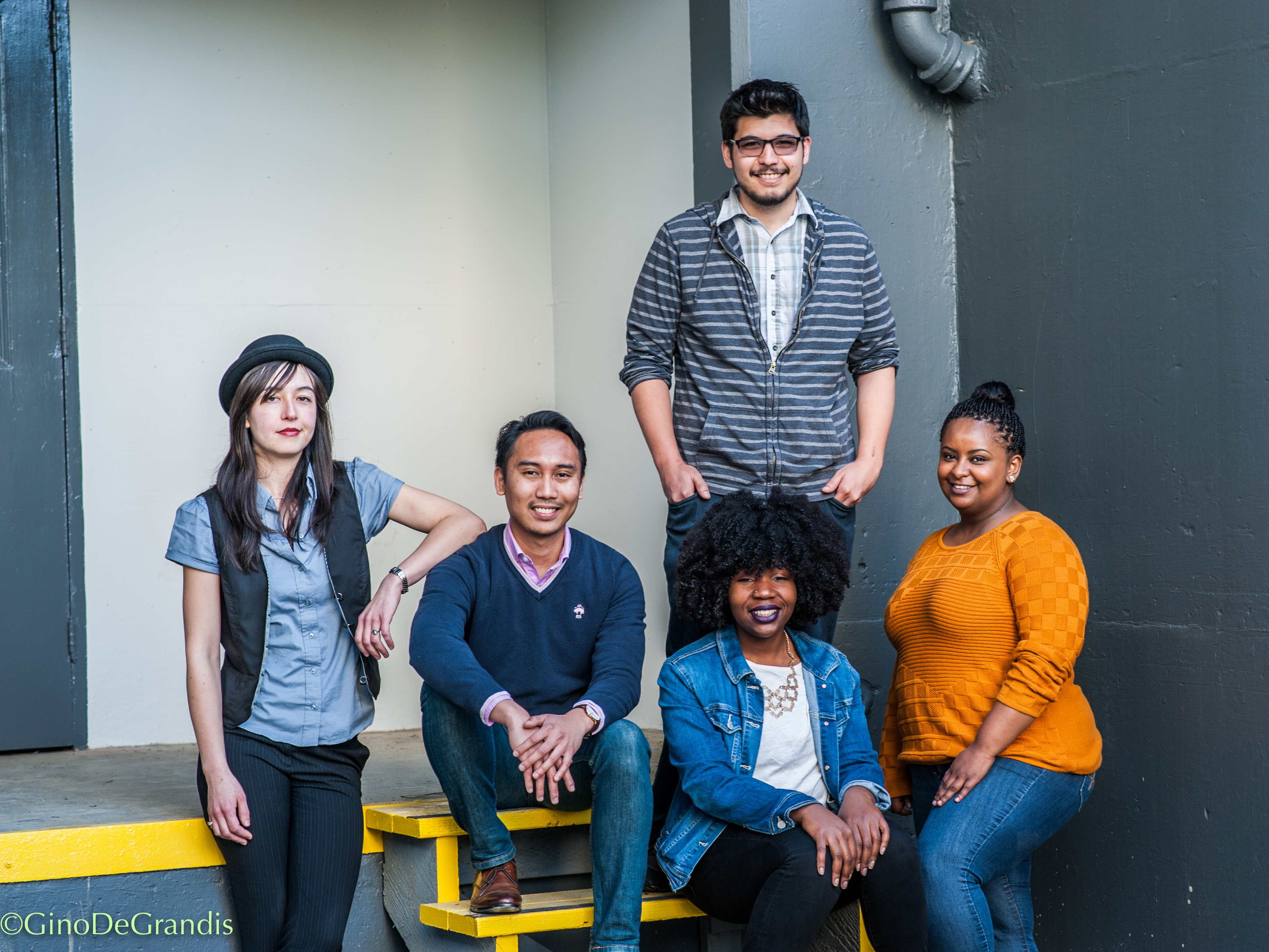 Five students sitting on steps
