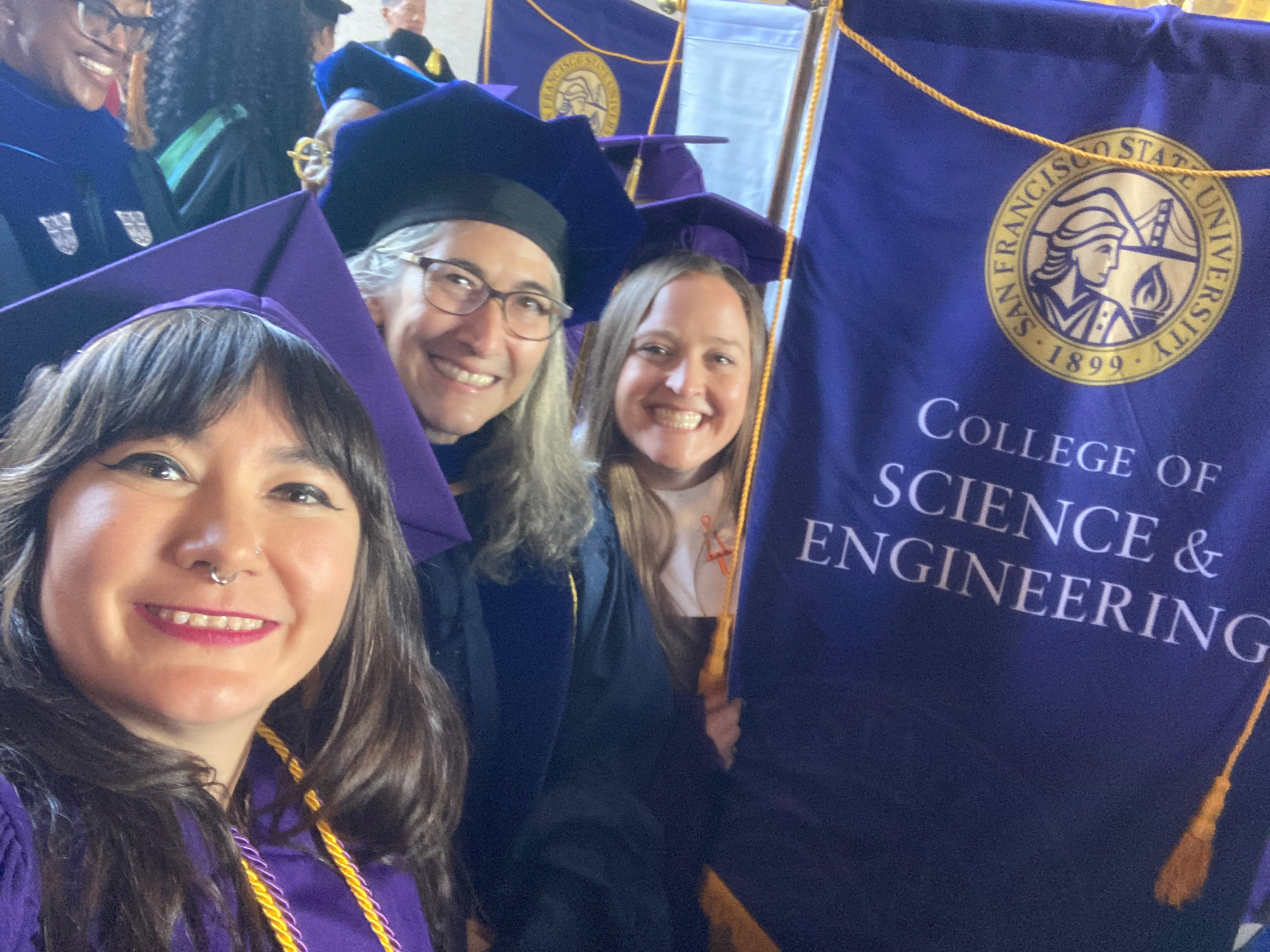 Two students with Dean Carmen Domingo at Commencement