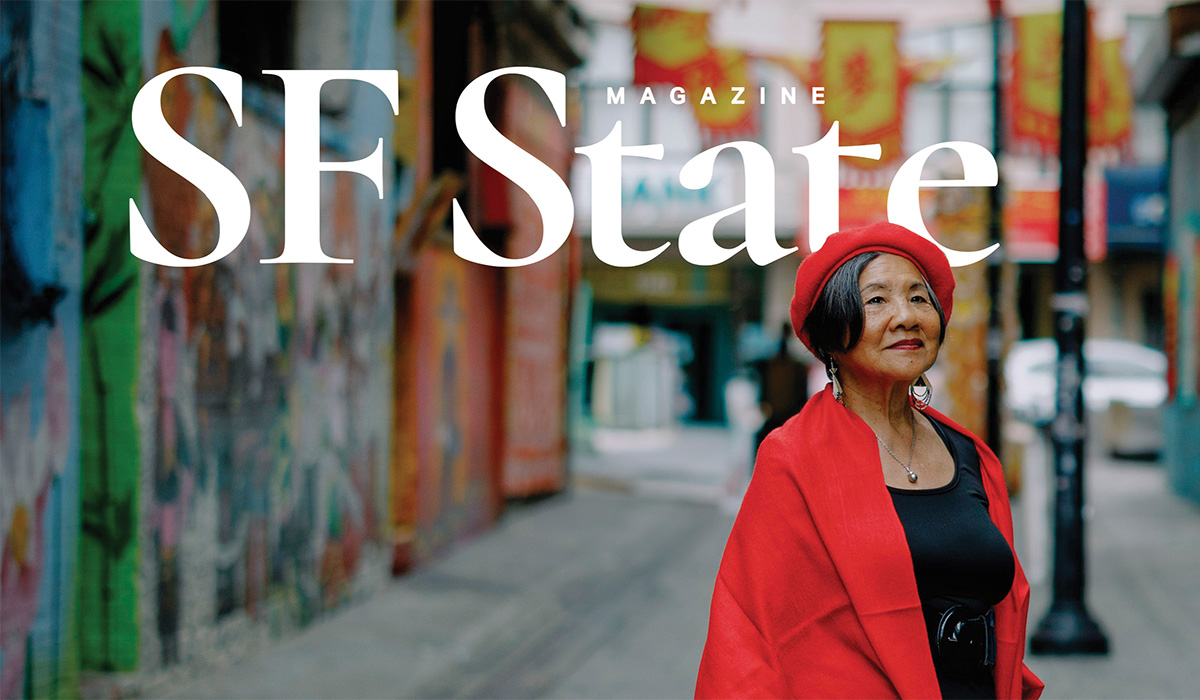 The cover of SF State Magazine featuring a photo of Genny Lim standing in an alley in San Francisco while wearing a red beret, red coat and black shirt