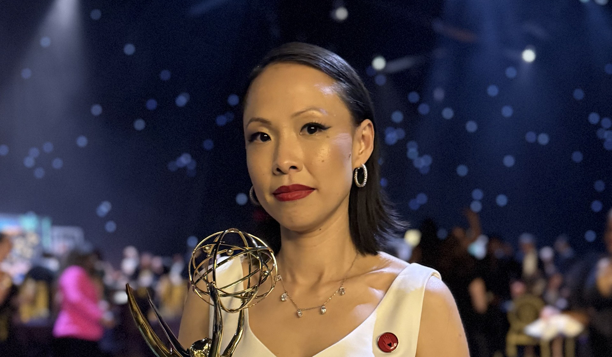 Poh Si Teng holds her Emmy Award statuette while standing at the awards ceremony