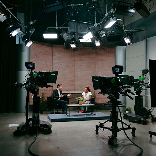 A student interviewing Whit Johnson in front of studio cameras