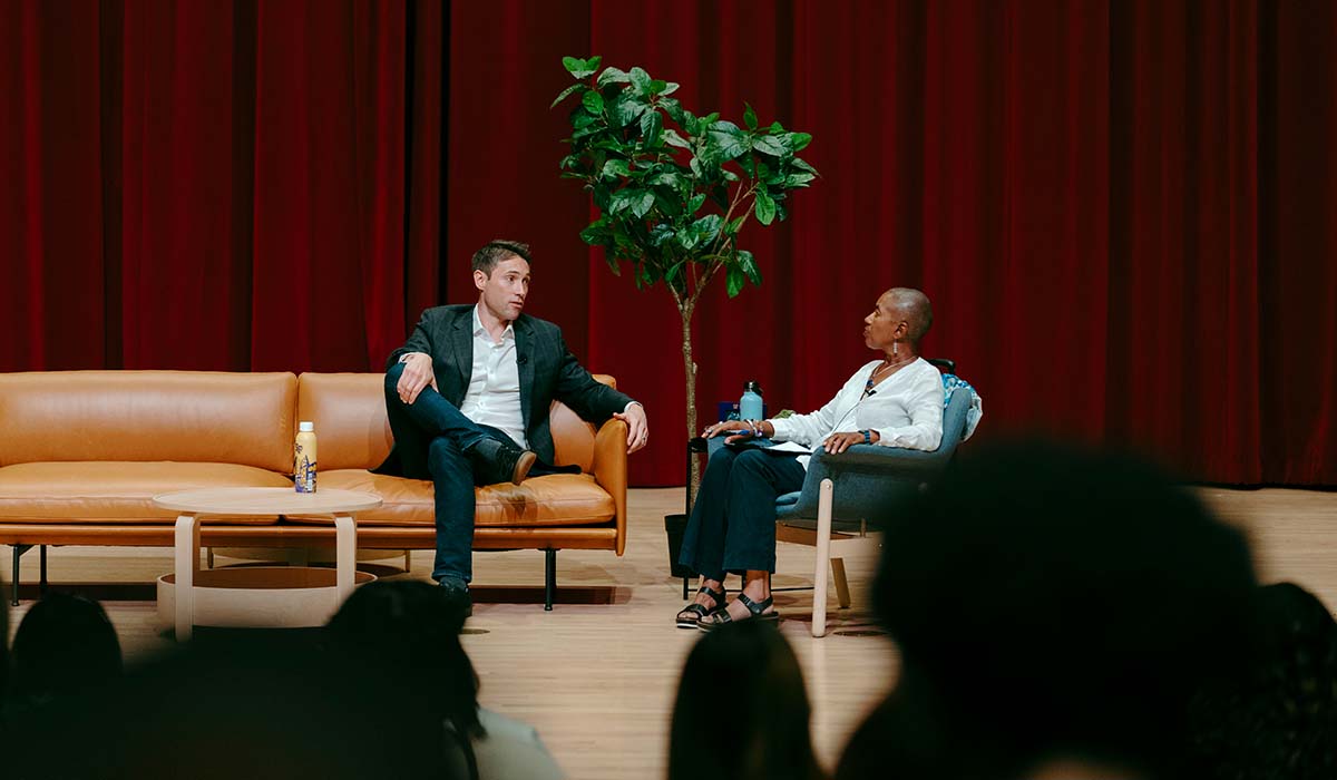 Whit Johnson and Venise Wagner sitting on a stage