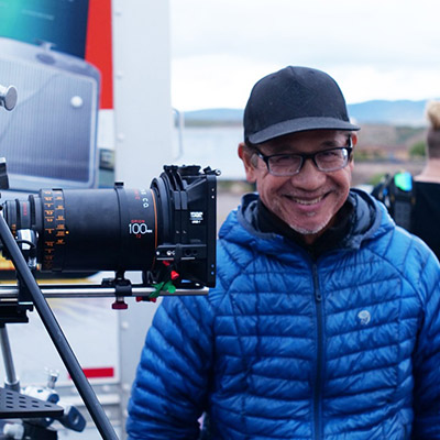 Alex Carig poses next to a camera