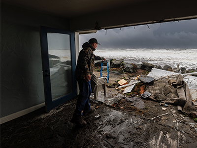 A man stares out at the destruction of his home 