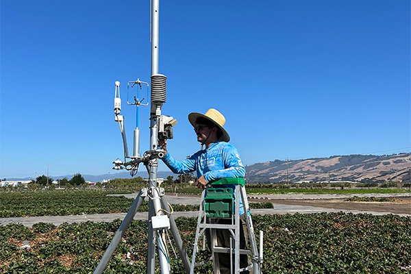 student on a ladder working on a research tower