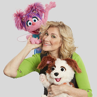 Leslie Carrara holds the pink fairy muppet Abby Cadabby and Tango a puppy