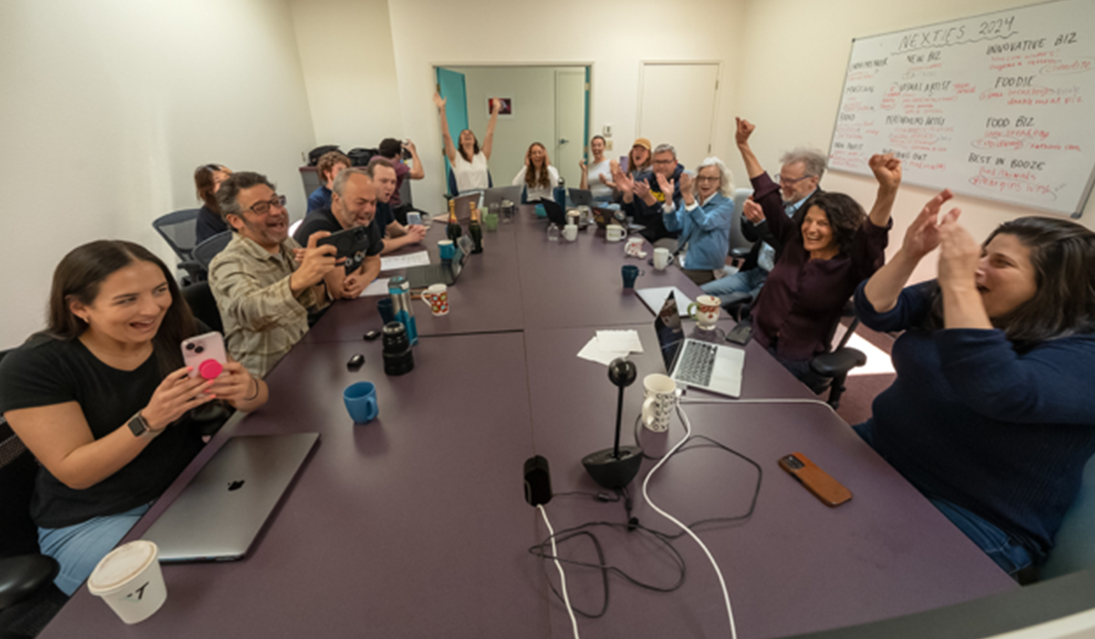 People sitting around a newsroom table