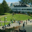 Students and others walk through the SFSU Quad, J. Paul Leonard Library and Business building