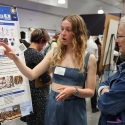 Female students talking to a female faculty about her research poster