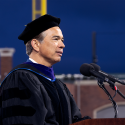 Rob Bonta speaks behind a podium on the platform at SFSU Commencement at Oracle Park