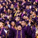 Students in purple caps and gowns celebrate at SFSU Commencement