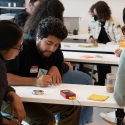 Three students at a table working on an activity together in the classroom.