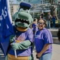 A person in a gator costume stands with a smiling person in a purple t-shirt