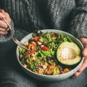 A bowl of salad in a woman's lap