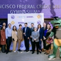 Alli Gator and a group of people in front of the new gym signage