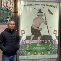 Marcelo Potosi stands on Market Street next to his Revitalizing the Culture poster for the series titled The Future of the Ramaytush Ohlone