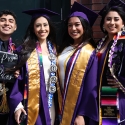 Four people in graduation attire smiling.