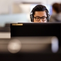 A student wearing headphones works on a computer