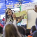A student reads to children in a classroom