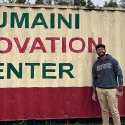 Vasav Juthani standing by Tumaini Innovation Center sign