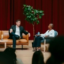 Whit Johnson and Venise Wagner sitting on a stage