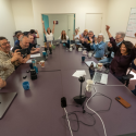 People sitting around a newsroom table