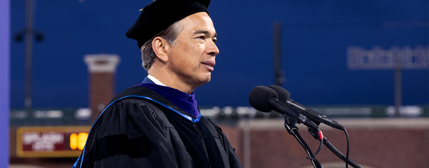 Rob Bonta speaks behind a podium on the platform at SFSU Commencement at Oracle Park