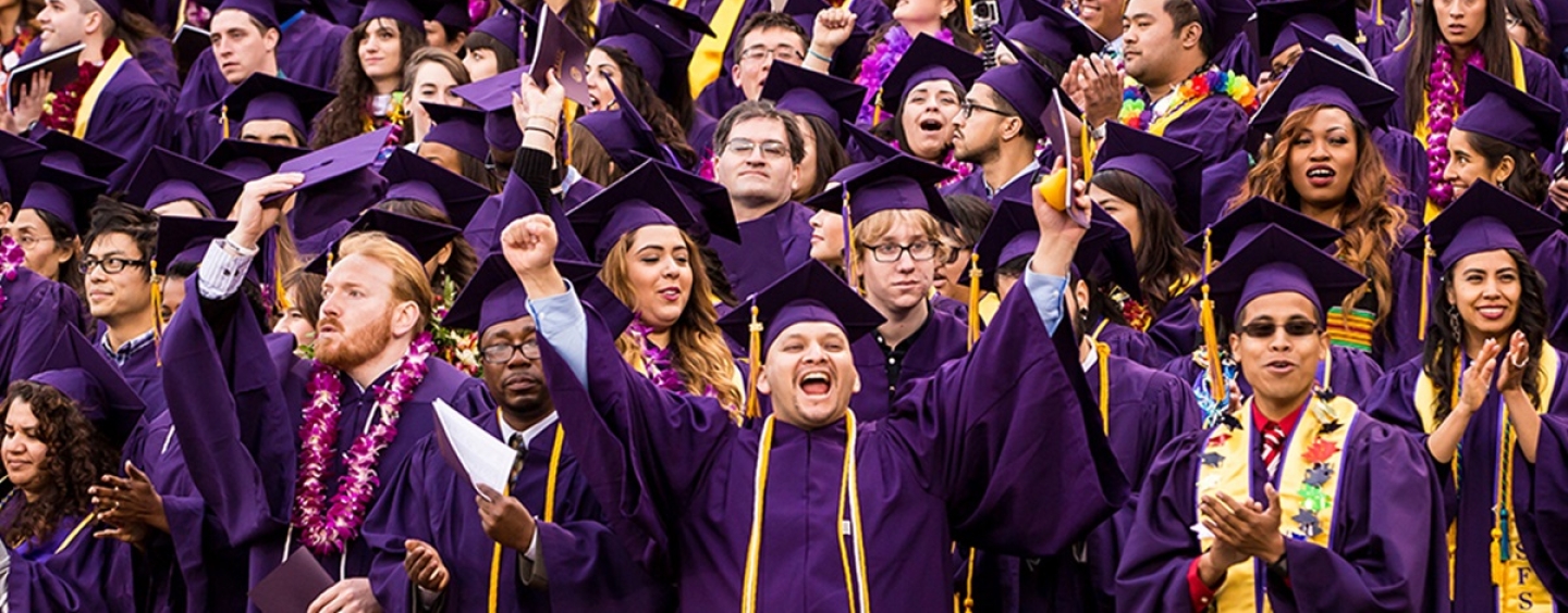 Students in purple caps and gowns celebrate at SFSU Commencement