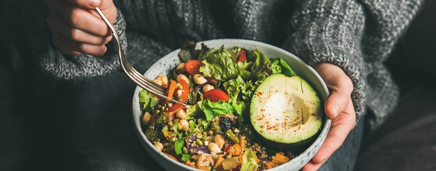 A bowl of salad in a woman's lap