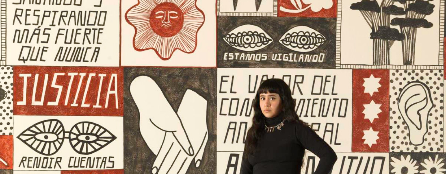 Liz Hernández standing in front her mural at the San Francisco Museum of Modern Art