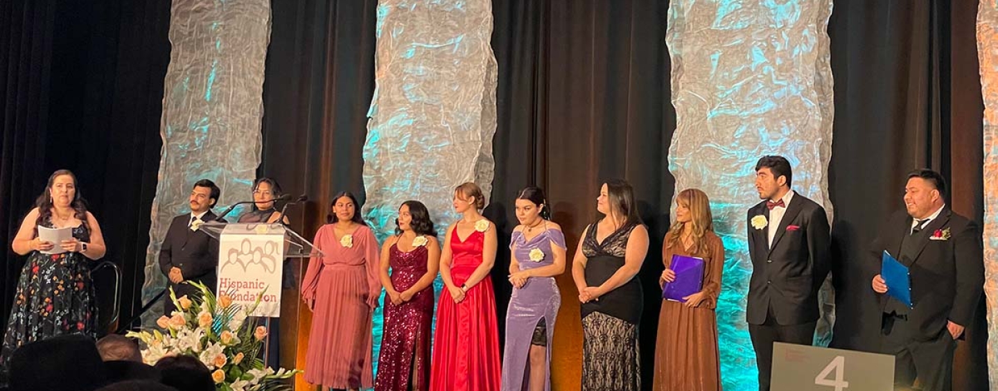 LITSI students scholars dressed in ball gowns and suits on stage