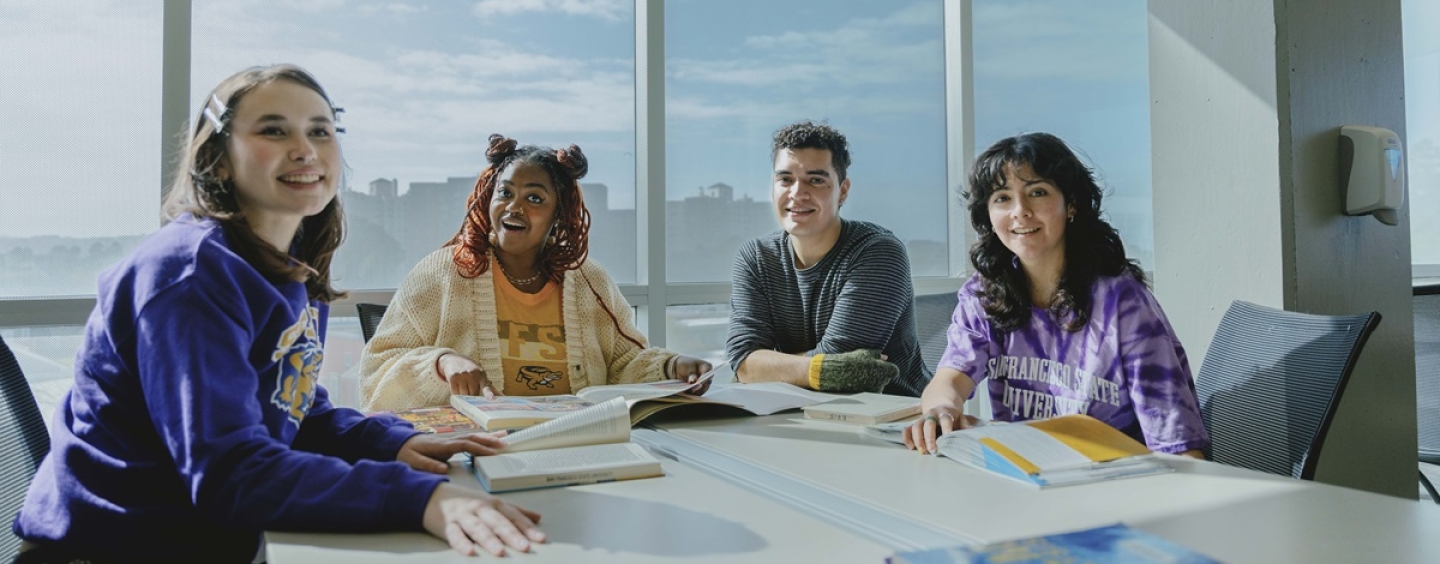 Four students sit at a table