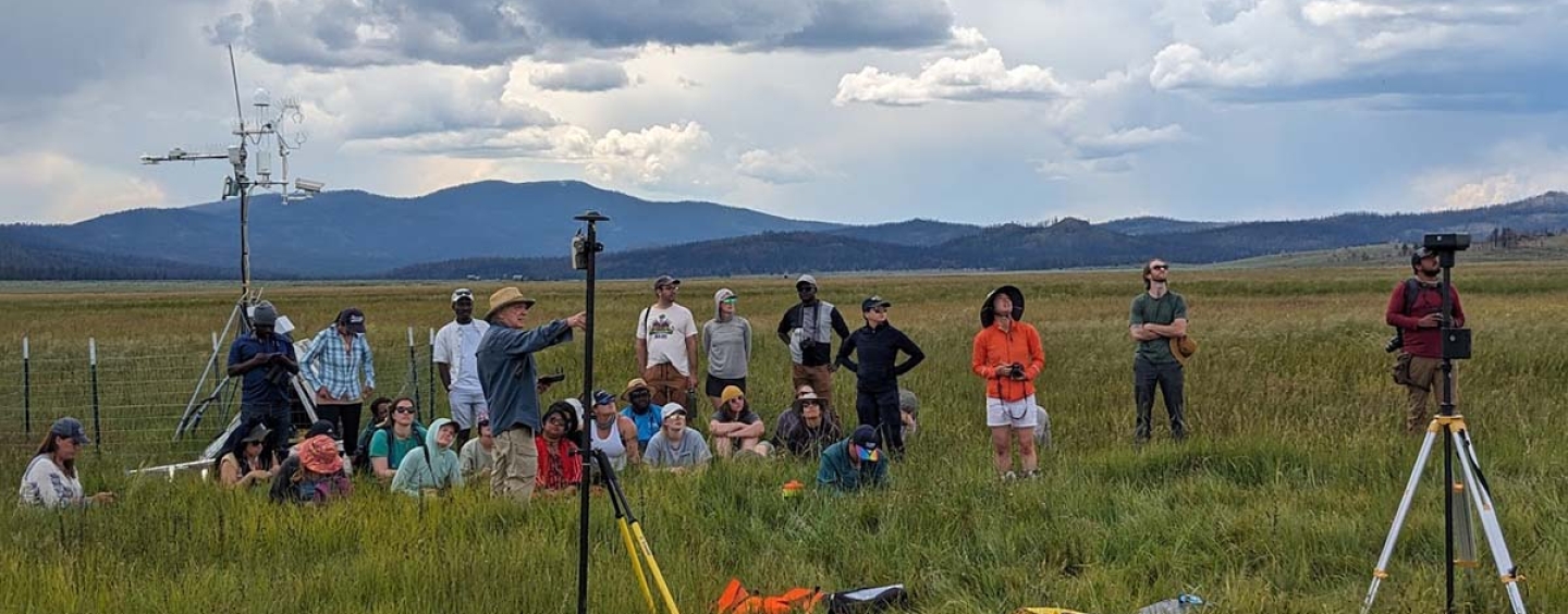 Students and faculty out in a field on a cloudy day