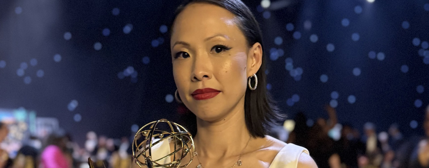 Poh Si Teng holds her Emmy Award statuette while standing at the awards ceremony