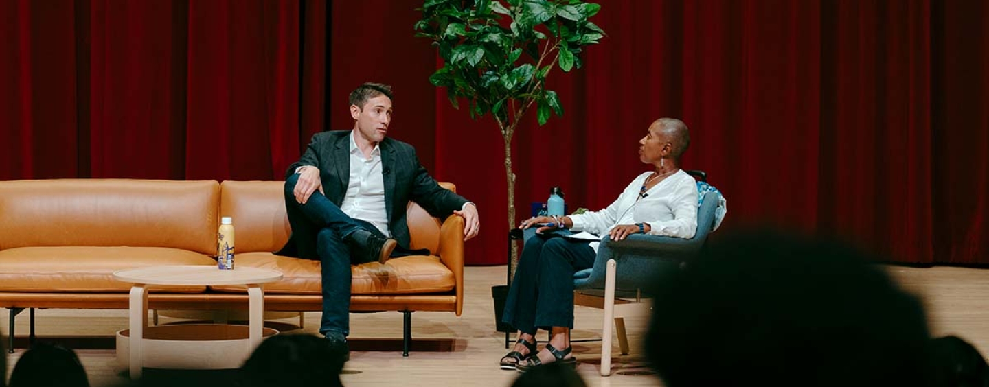 Whit Johnson and Venise Wagner sitting on a stage