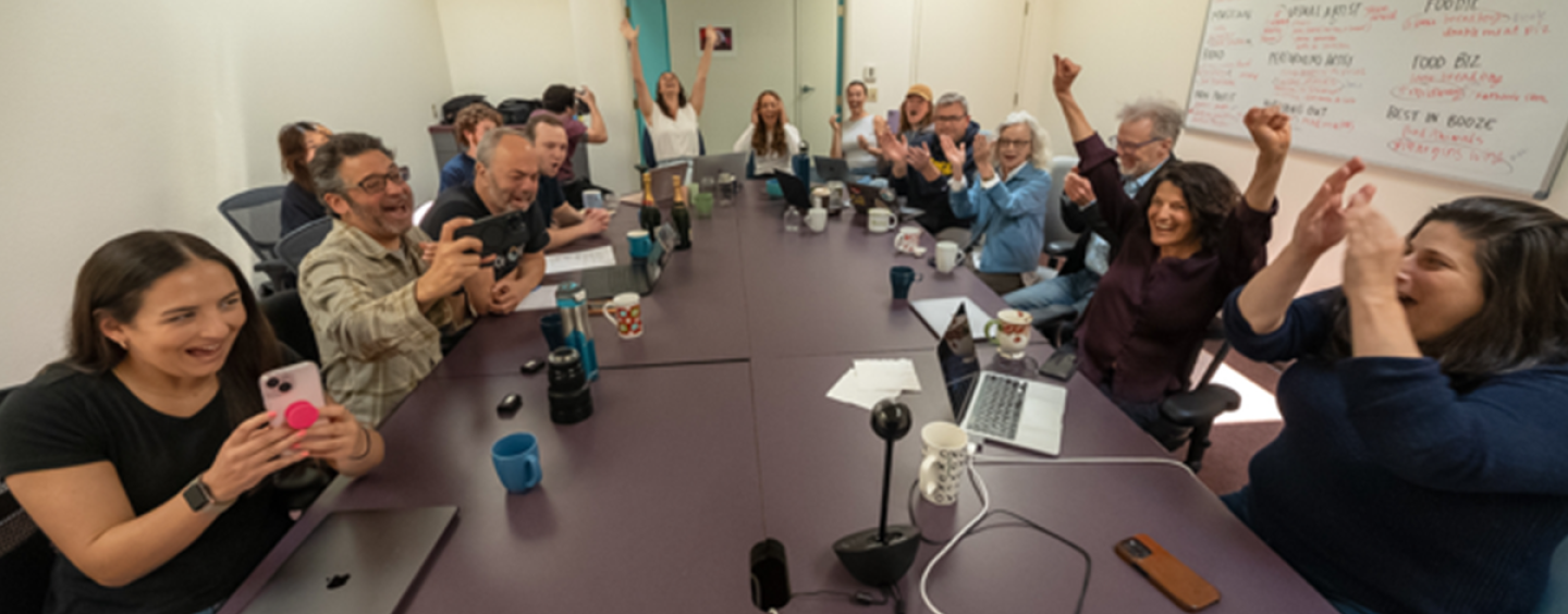 People sitting around a newsroom table