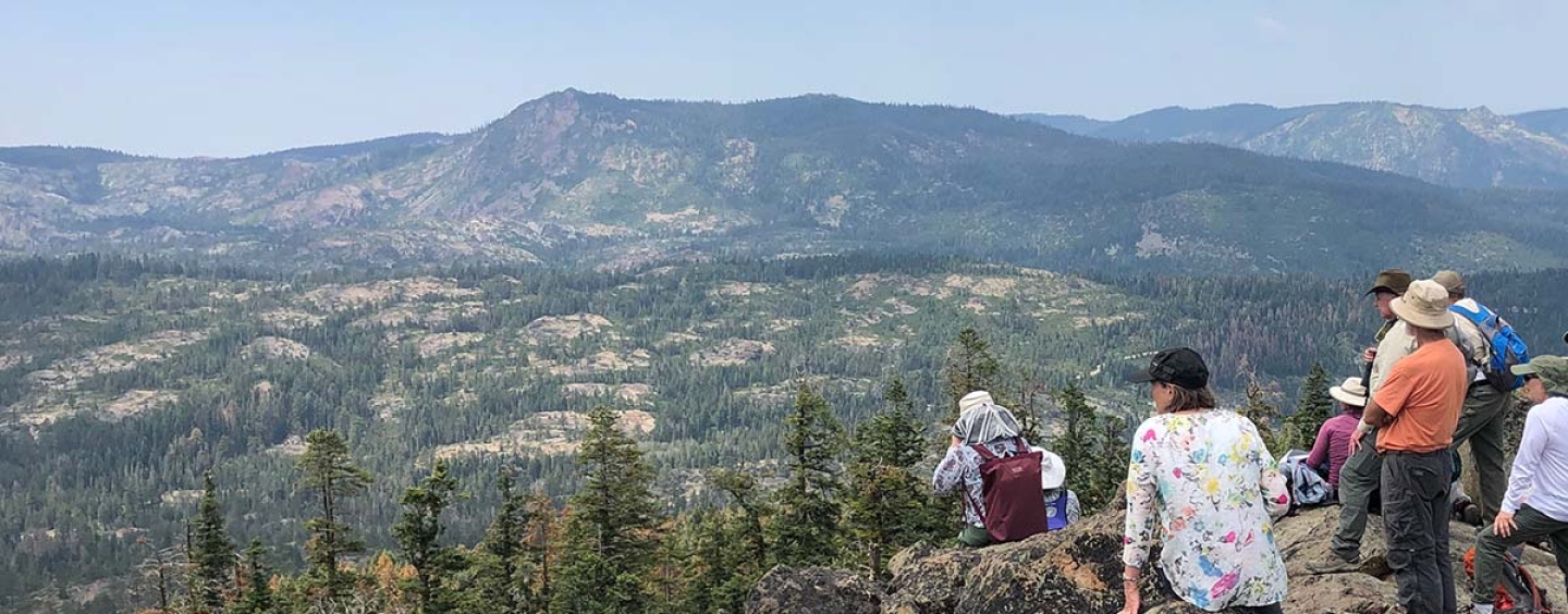 Students on a mountain top looking at a scenic view