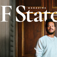 The SF State Magazine spring/summer 2026 issue cover photo of Ryan Marchand standing in front of a wooden door while wearing a gray sweatshirt