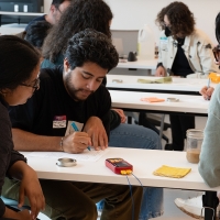 Three students at a table working on an activity together in the classroom.