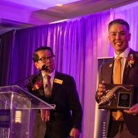 Two adults on the stage at the alumni hall of fame event,