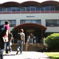 Students walk into the Lam Family College of Business building